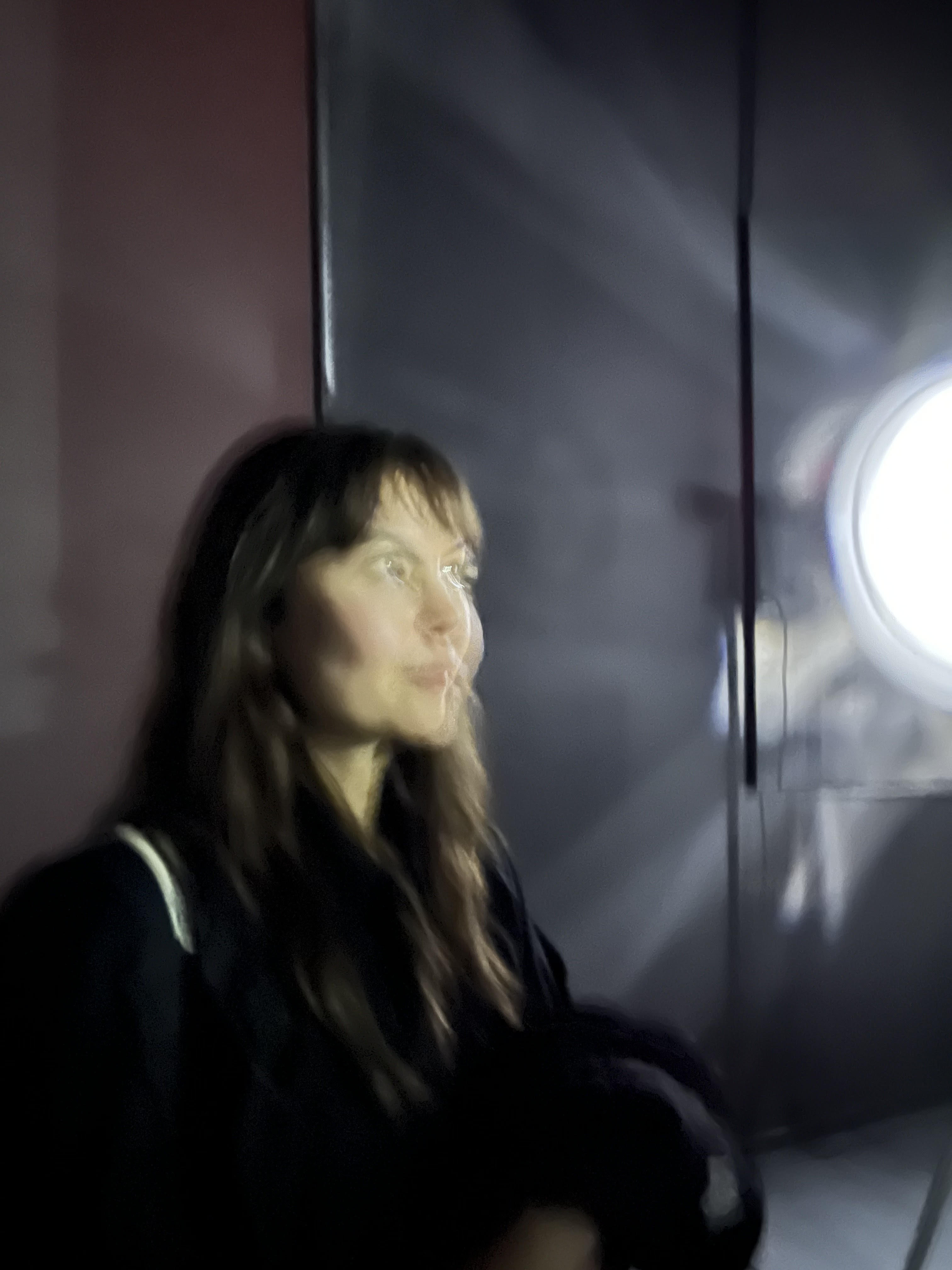 A woman with dark hair looking off to the light
